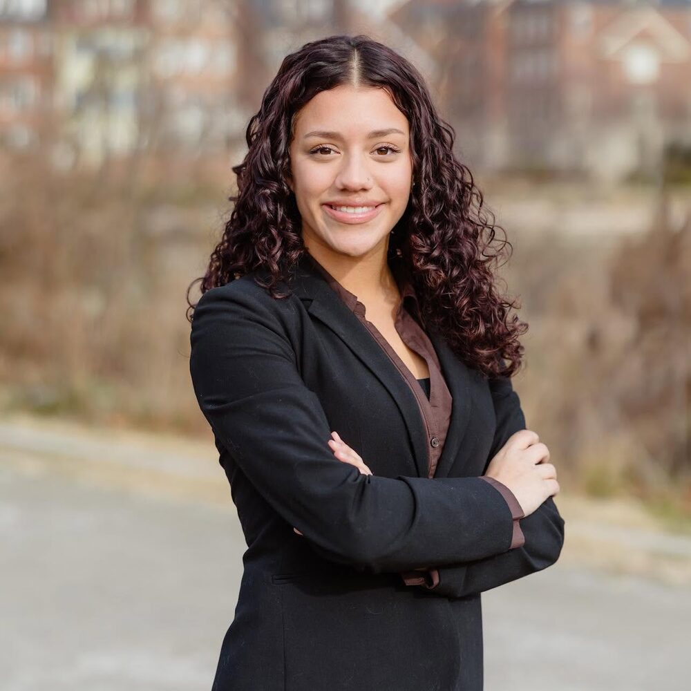 Jaelyn Cruz in a black blazer, arms crossed, smiling