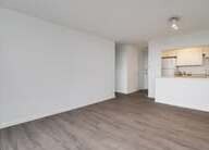 Empty living area looking toward the kitchen