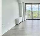 Living room with a glass door out to the balcony